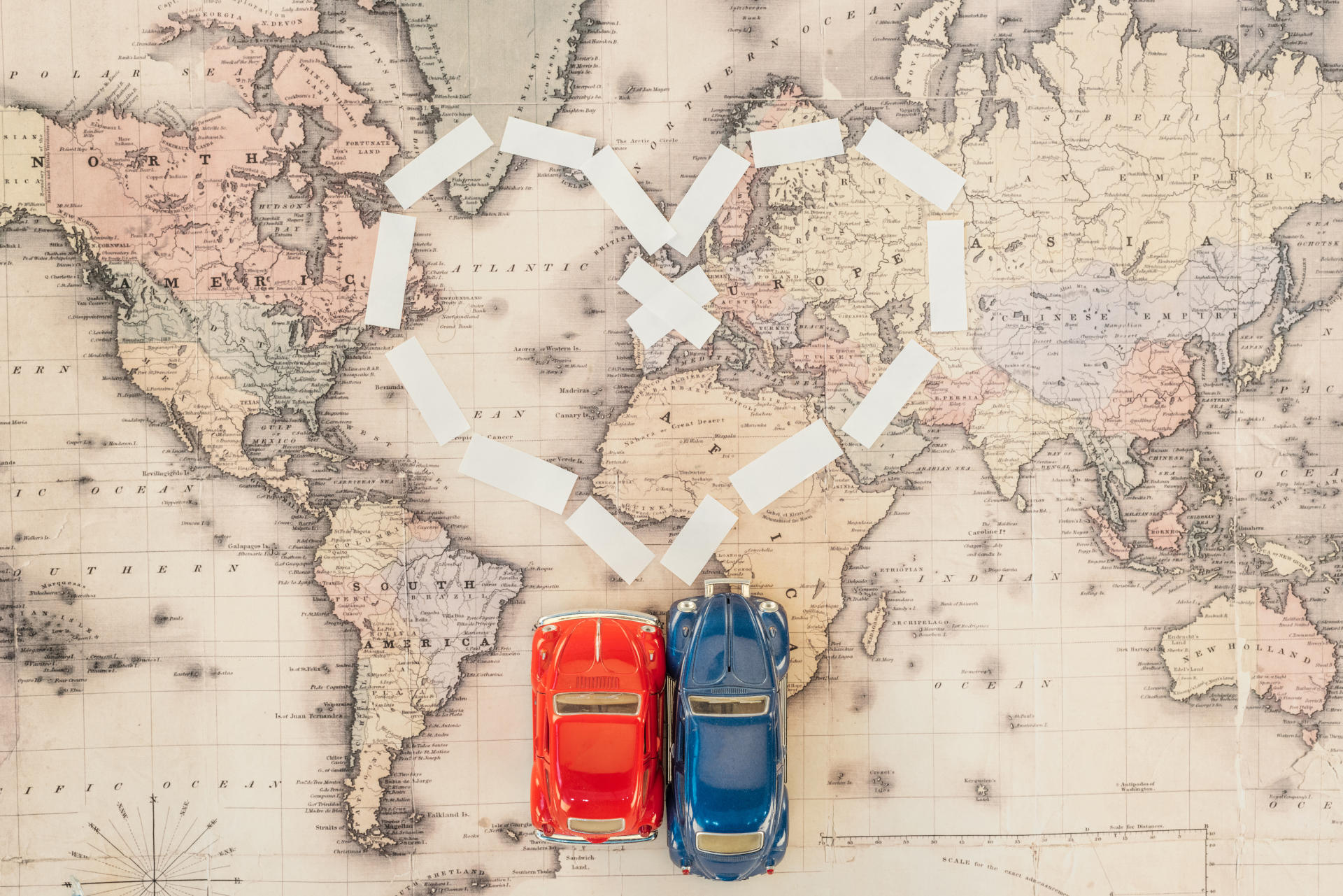 Top view of red and blue toy cars on world map